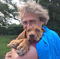 Foto von Prof. Dr. Martin Brüne mit seinem Hund auf dem Arm.